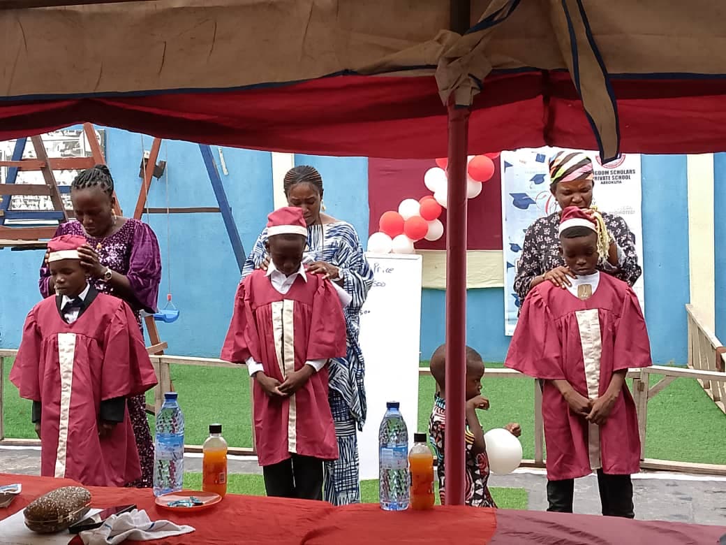 Teachers proudly gowning graduates on stage